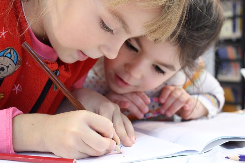 girls-on-desk-looking-at-notebook-insert feature